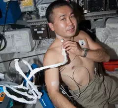 In this image, JAXA astronaut Koichi Wakata, Expedition 38 Flight Engineer, demonstrates the ultrasound used to collect data for the Cardio Ox investigation, in the Columbus Module.